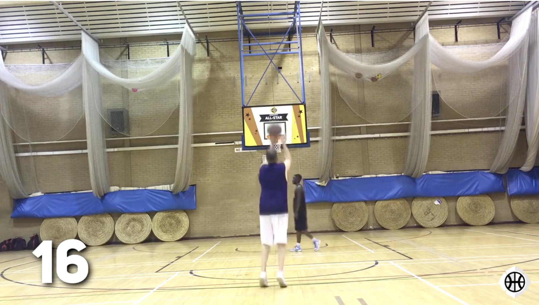 Basketball player practising a jump shot during an indoor coaching session